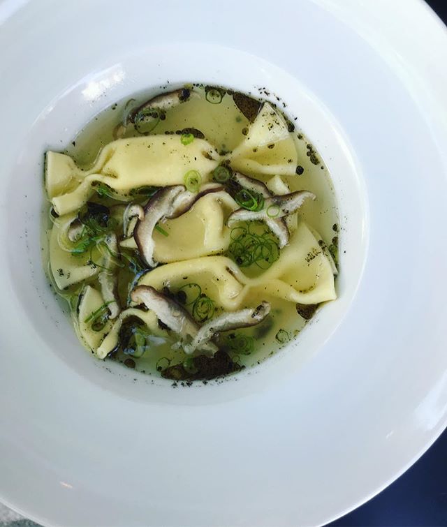 Carmelle pasta filled with corn-Parmesan fonduta. Clear chicken-dashi . Thin sliced shitake mushrooms, charred scallion butter.